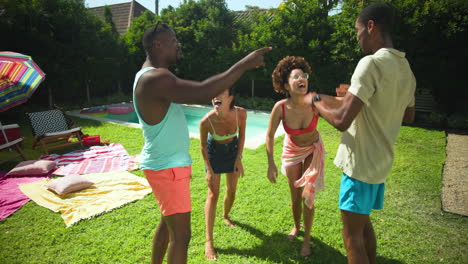 diverse friends laughing and dancing together on sunny day at backyard pool party