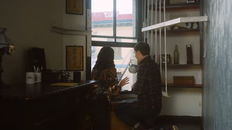 couple waters plants at home and laughs.
