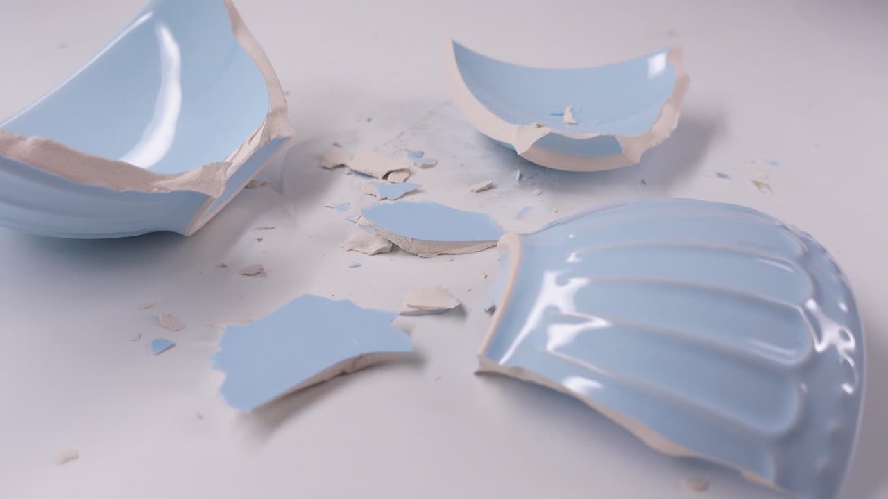 Shattered Light Blue Ceramic Bowl Pieces on White Background