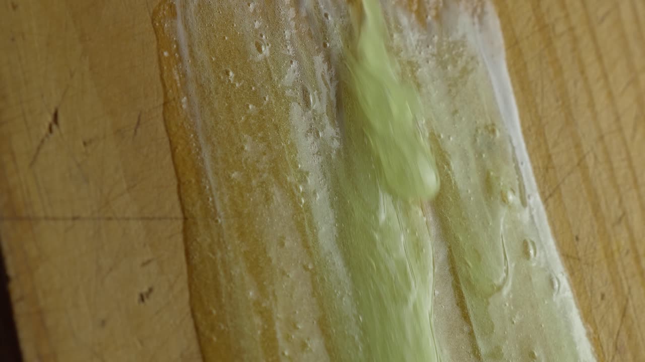 끈적끈적한 액체가 나무 표면에 떨어지고 - 클로즈업