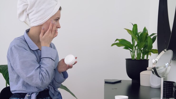 Junge Frau legt Feuchtigkeitscreme auf