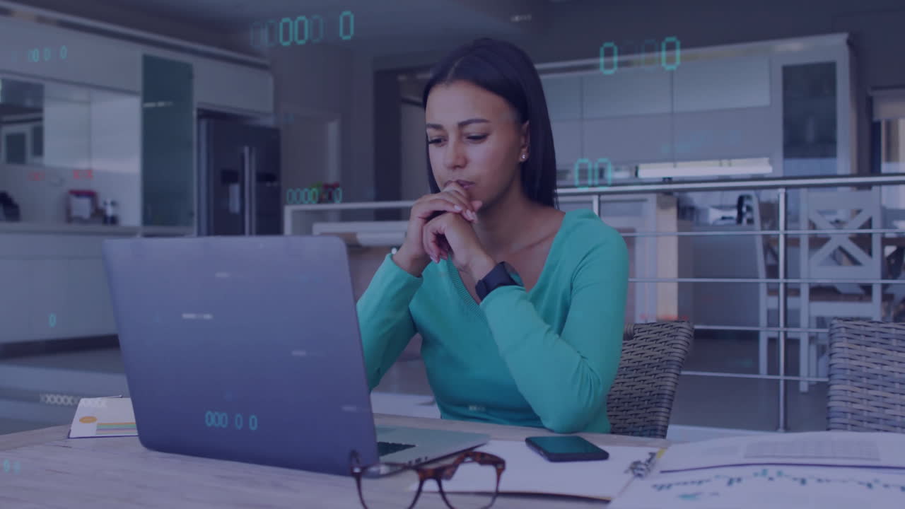 Woman working on laptop with digital data animation overlay in kitchen