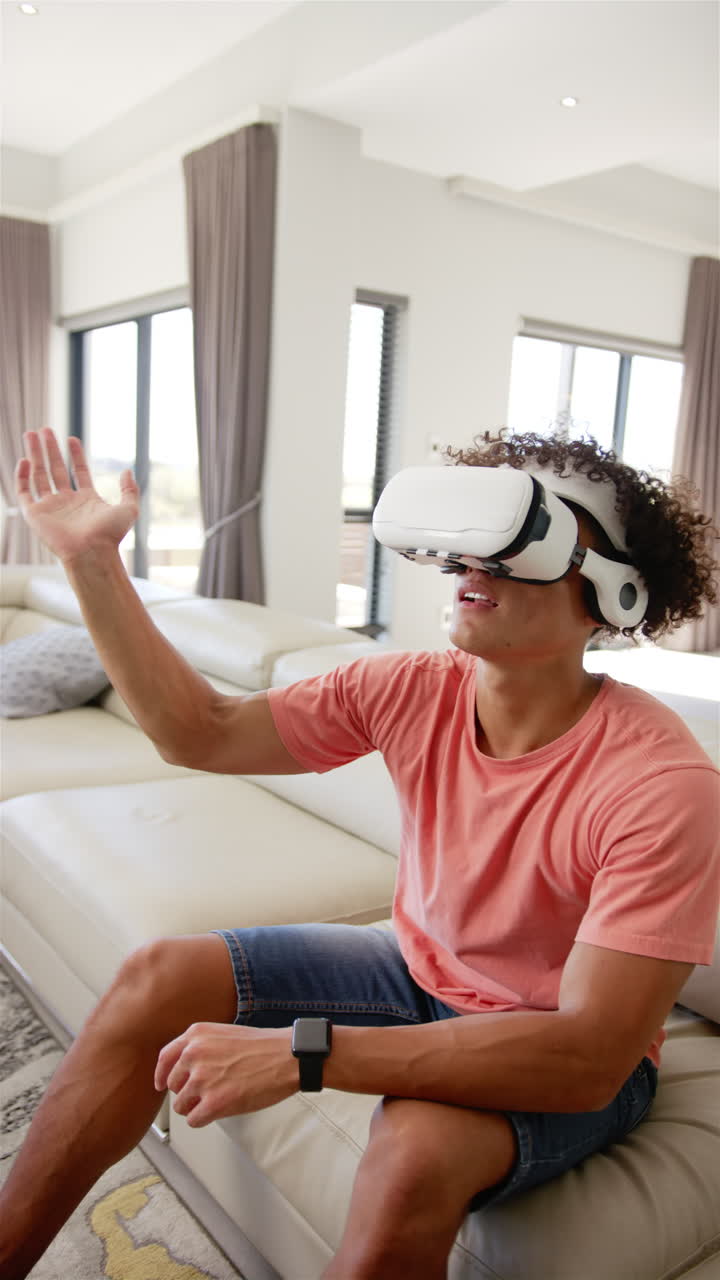 Vertical video: A young biracial man is engaged with virtual reality