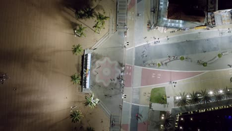 bird's eye aerial night shot of the main plaza in the center of tambaú with the city sign, a boardwalk along the beach, restaurants, and apartments in the capital city of joao pessoa, paraiba, brazil