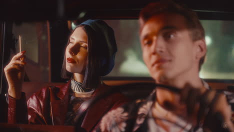 attractive woman smoking in passenger seat and talking to man driving at night