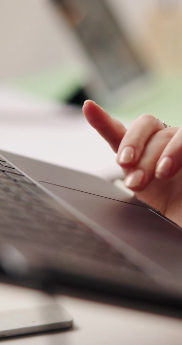 Close-up of Woman Using Laptop Trackpad and Typing on Keyboard