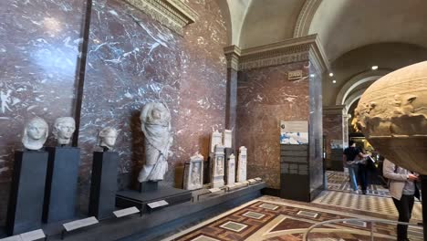 visitors admire sculptures and artifacts in the louvre