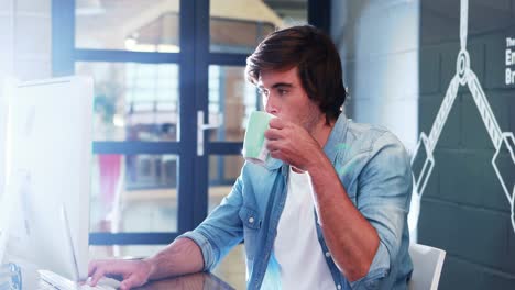Hombre-Tomando-Café-Mientras-Trabaja-En-La-Computadora