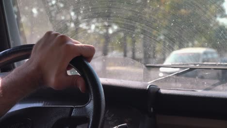 Toma-Cercana-De-La-Mano-Que-Sostiene-El-Volante-Conduciendo