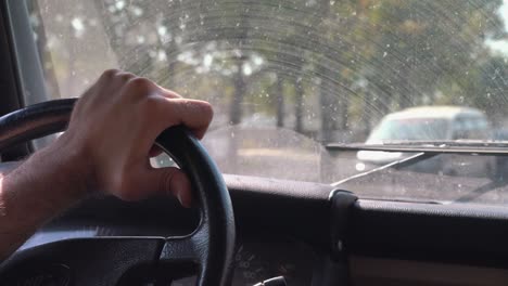 toma cercana de la mano que sostiene el volante conduciendo