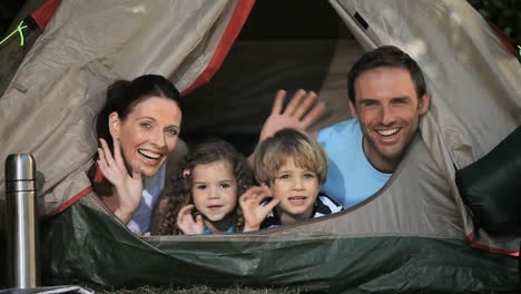 family smilling at the camera in a tent