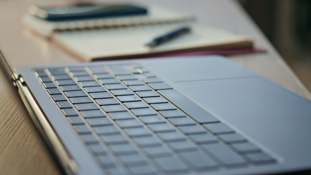 Open laptop placed table near copybook close up. Company workplace with computer