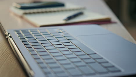 Open laptop placed table near copybook close up. Company workplace with computer