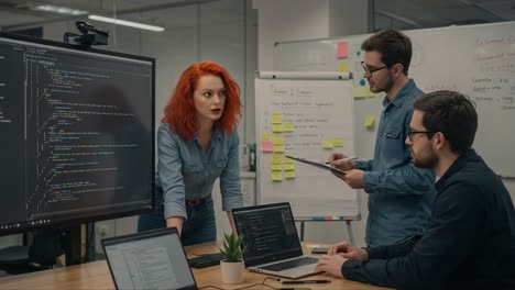collaborative team meeting: professionals engaging in problem solving and development strategies with technology in modern office environment