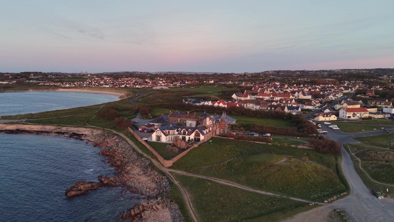 Grandes Rocques Guernsey. Droneoptagelser af hotel, bugter og kystvej i den sene eftermiddagssol på en klar dag med omfattende udsigt over øen
