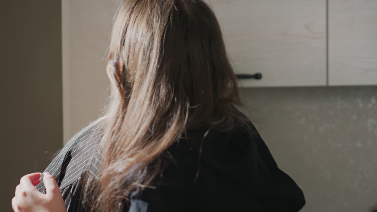 college girls making playful hand gestures while embracing warmly in modern apartment hallway near kitchen cabinets, sharing joyful reunion and affectionate friendship moment