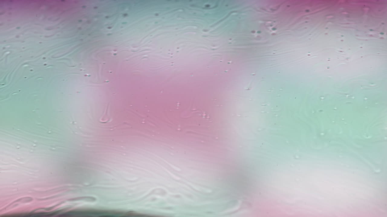 glowing iridescent textures in macro soap film footage