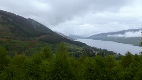 Cinematic-zoom-out-drone-shot-of-highland-village-with-misty-clouds-over-it