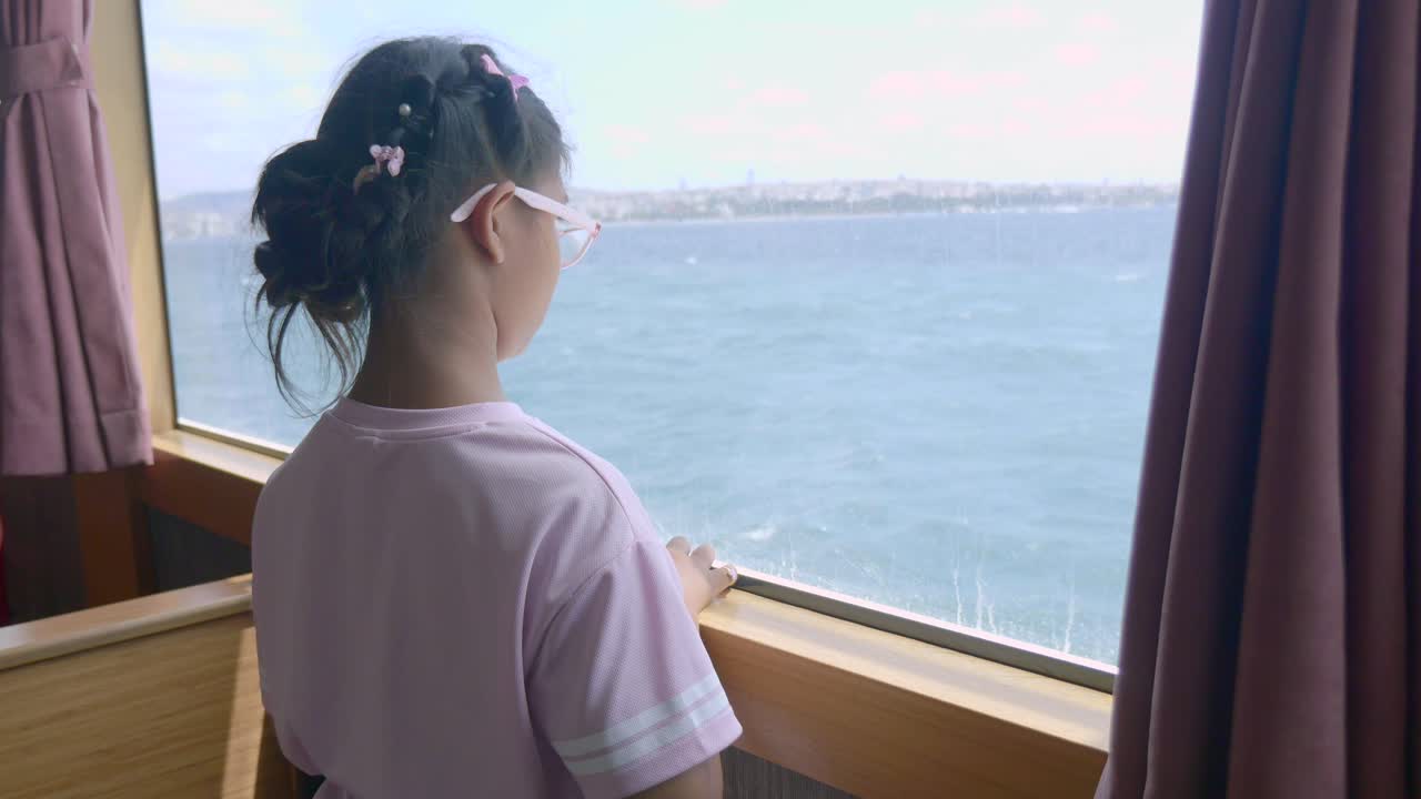 Girl looking out the window on a ferry