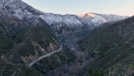 cars in the eoad driving on a big mountain with snow at ontario baldy mountain