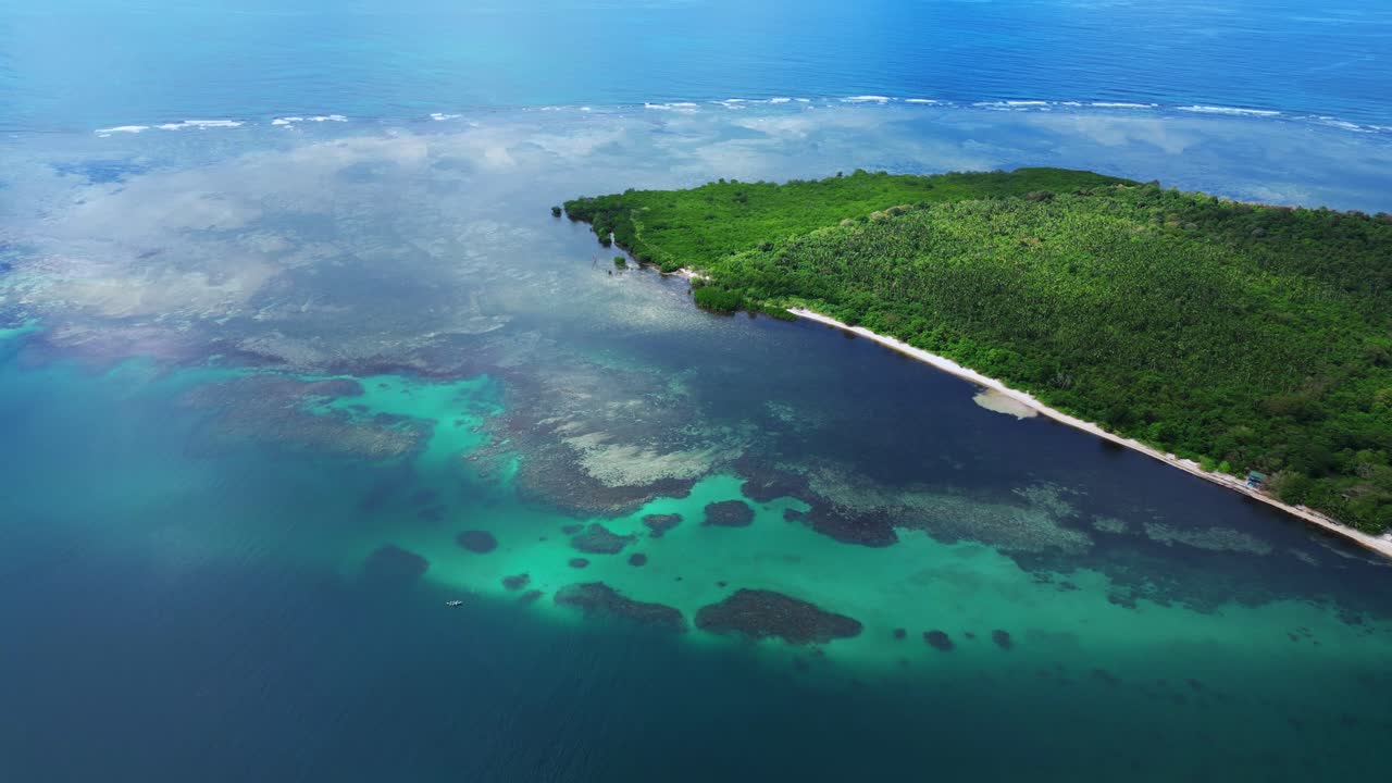 Ripresa aerea dall’alto con drone dell’isola di Magalawa che rivela intricate barriere coralline, acque turchesi poco profonde e spiagge sabbiose circostanti