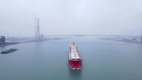 large cargo ship on detroit river with gordie howe international bridge in background