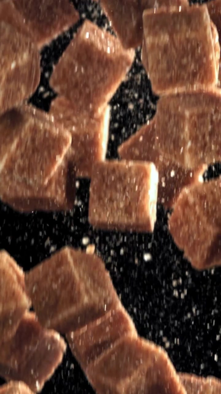 Brown Snack Pieces Falling in Slow Motion with Sugar Particles