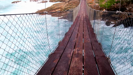 pov on storms river suspension bridge over frothing rough seawater, tsitsikamma