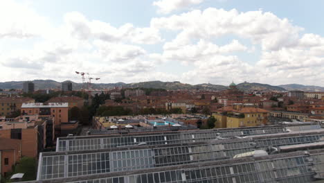 Construyendo-Invernaderos-En-La-Azotea-Con-Una-Vista-Majestuosa-De-La-Ciudad-De-Bolonia,-Drones-Aéreos-Sobrevuelan-La-Vista