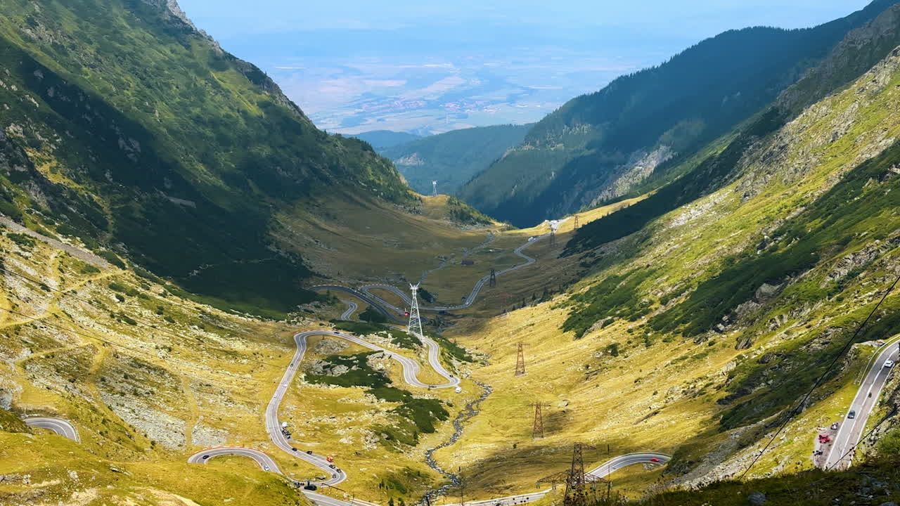 Scenery of mountains and valley among them is half-shaded by the clouds. Aerial perspective on the stunning Transfagarash road in Romania