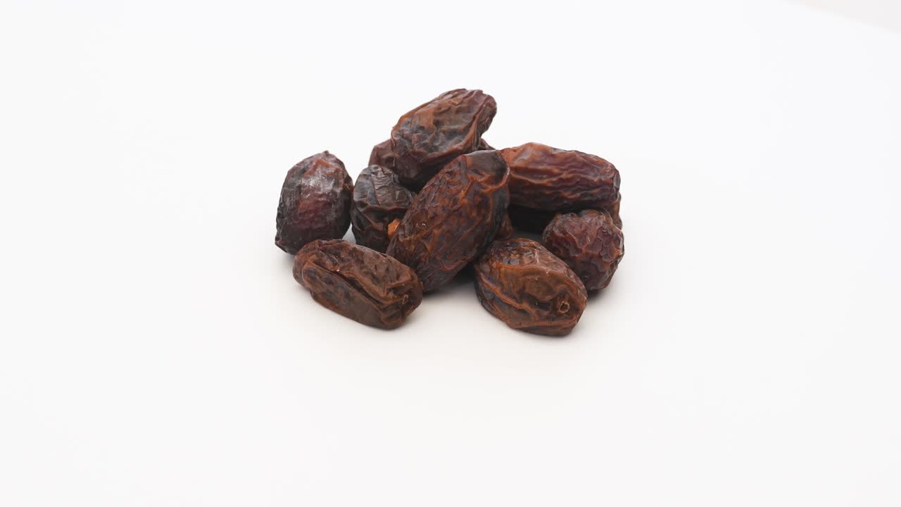 Date Fruit on White Background. Rotating on Turn Table. Iftar Food Mostly Eating in Ramadan. Extreme Close Up Shot. High Angle View. 4K Resolution.