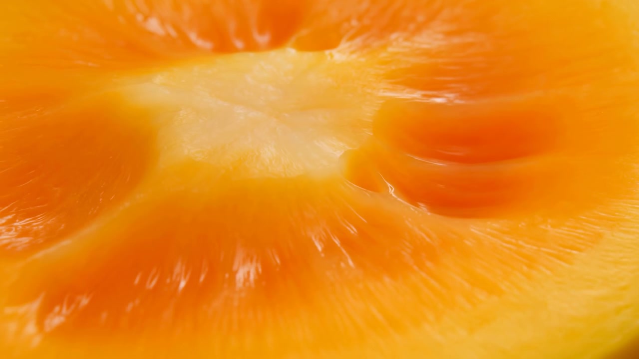Nærbillede afslører blankt orange frugtkød, fine membraner og bleg marv omkring citrusmidten, med mættede varme toner og blide højdepunkter, der fremhæver fugtig naturlig tekstur