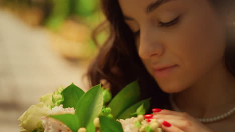 beautiful bride admiring flowers in garden. woman touching flower petals in park