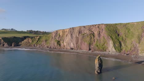 Acantilados-Estáticos-De-Drones-Y-Pila-De-Mar-En-Marea-Llena,-Costa-De-Cobre,-Waterford,-Irlanda