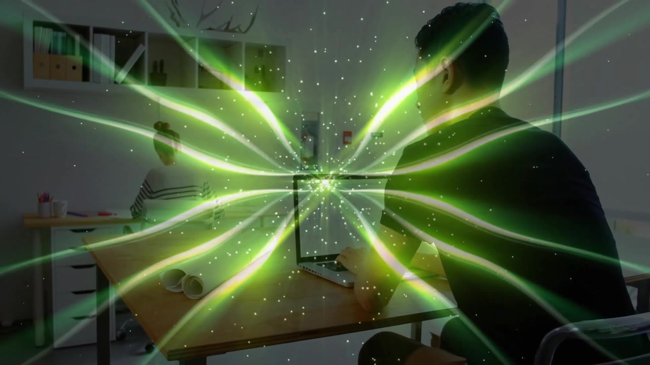 Man Working on Laptop with Digital Green Light Effects in Office