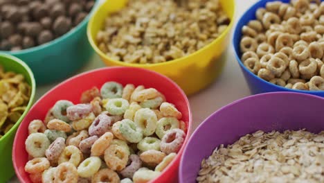 video of cereals in colorful bowls on wooden kitchen worktop