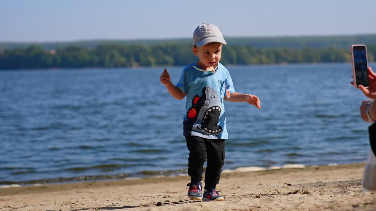 Small boy playing on a beach. Having fun on sunny river beach.