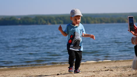 small boy playing on a beach. having fun on sunny river beach.