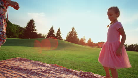 mother with daughter having fun outdoor. woman and girl jumping in city park.