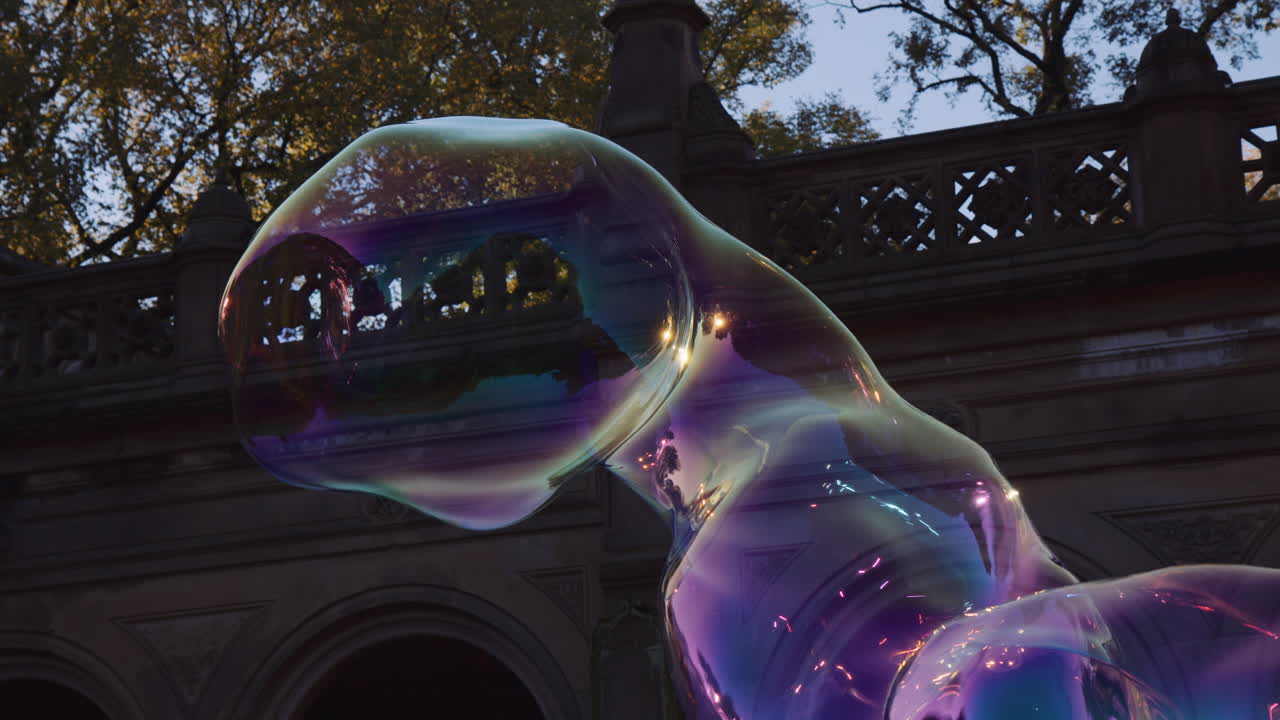 Big Giant Soap Bubble Shape Floating in Air, Dragged by Breeze, Moving Expanding and Bursting, Colorful Transparent Shape Blast Burst Outside in Park