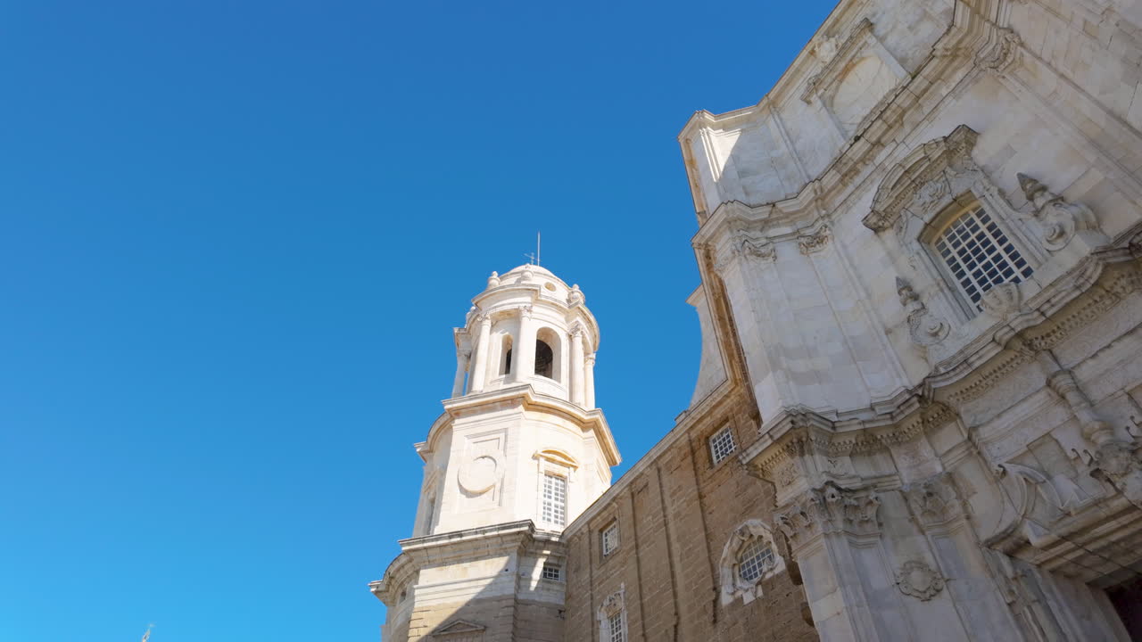 Bell tower of a baroque church against the clear sky in C&aacute;diz
