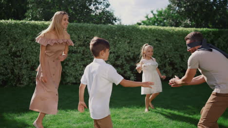 Hombre-Con-Los-Ojos-Vendados-Jugando-Al-Aire-Libre-Con-La-Familia.-Familia-Pasando-Tiempo-Juntos