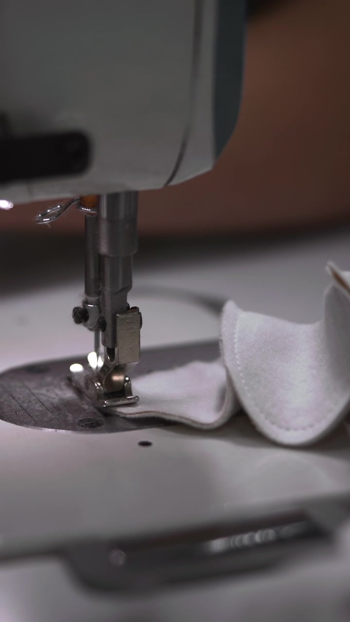 Closeup Sewing Foot Stitching White Fabric. Needle And Presser Foot Work Together To Form Neat Seam, Operator