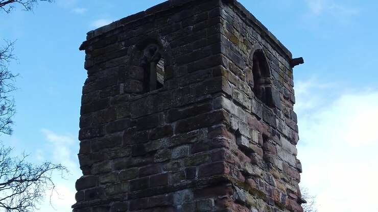 Esterno della storica torre in muratura della Windleshaw Chantry in slow motion contro il cielo blu