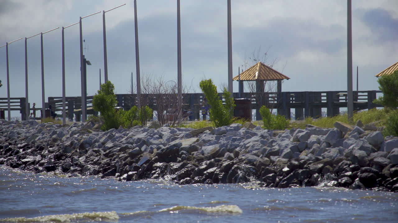 Male Walking with Fishing Pole On a Gulfport-Biloxi Mississippi Beach Pier During the Day