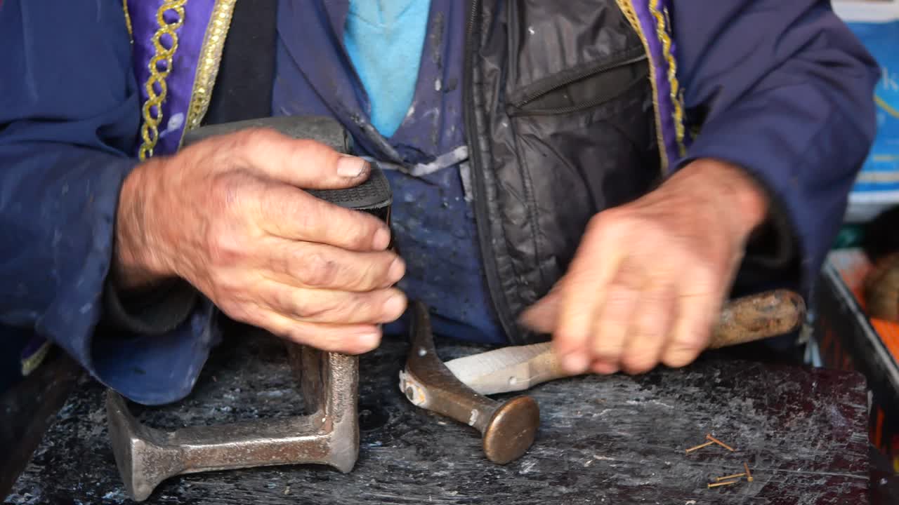 신발공 이 망치 와 도구 로 신발 을 수리 한다