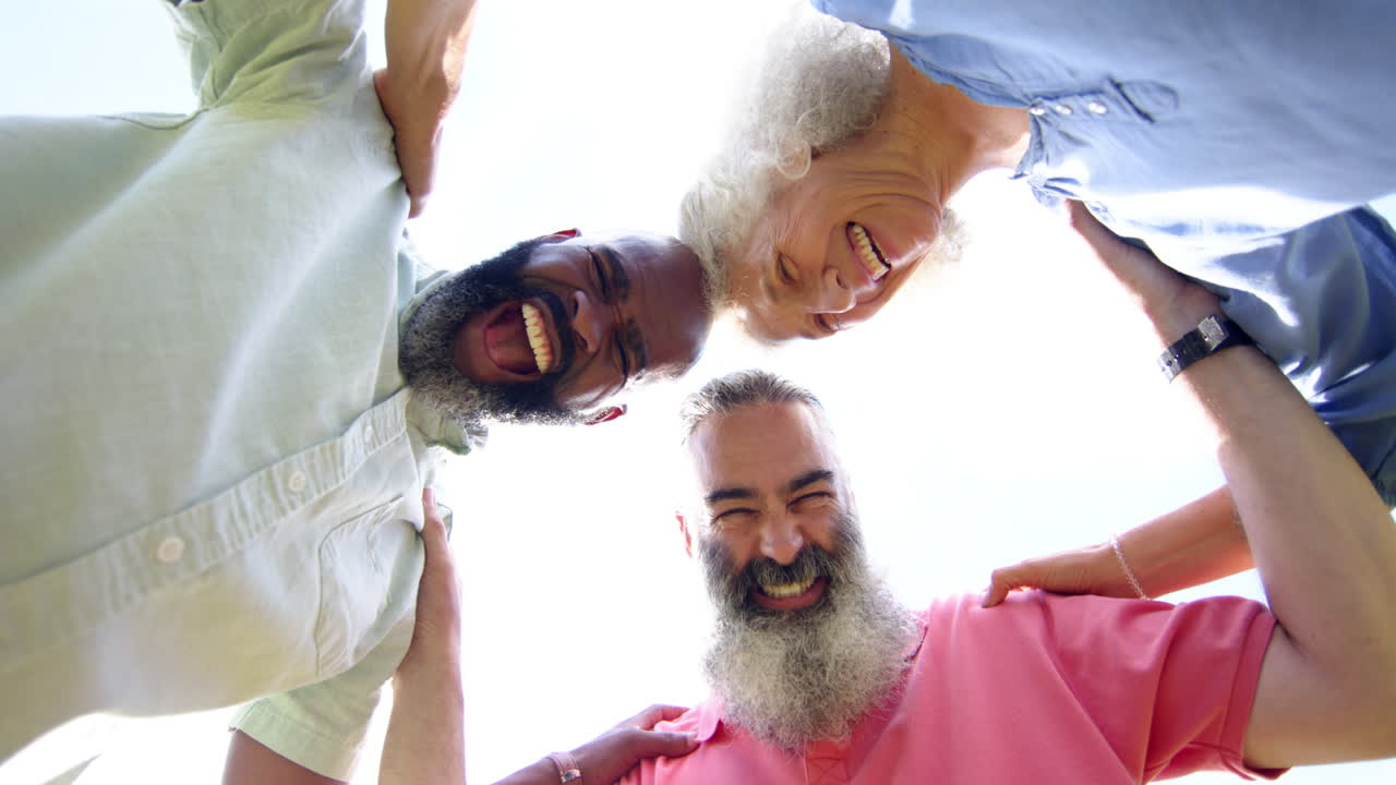 Laughing and embracing, senior friends enjoying time together outdoors
