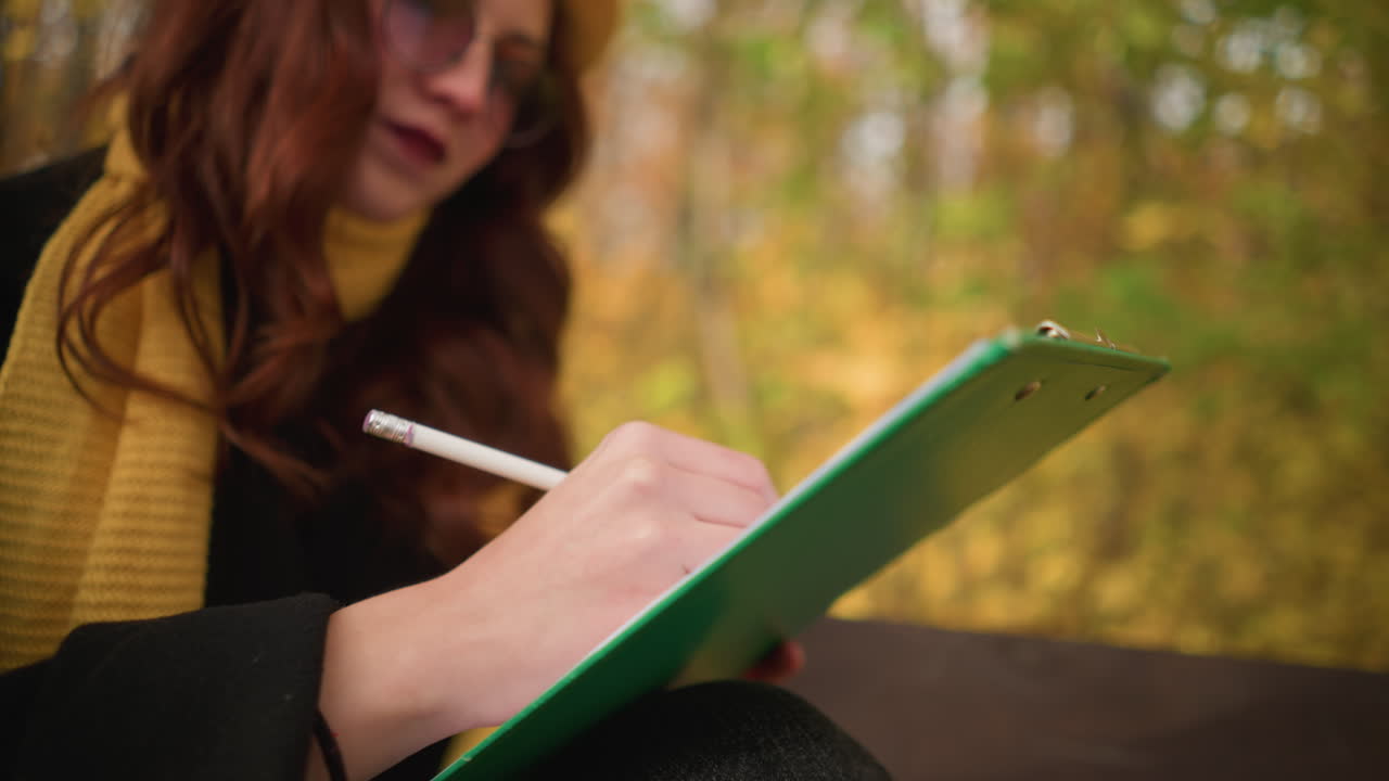 Close up of creative mind sketching thoughtfully on canvas with blurred autumn leaves in background, focus on artistic expression, pencil strokes, and deep concentration in a serene outdoor setting