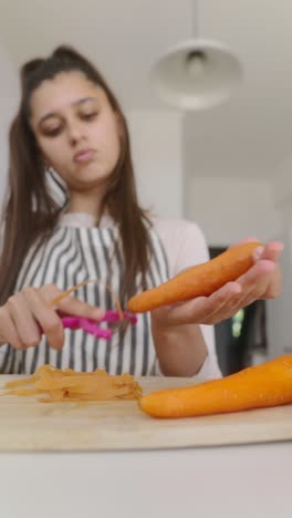 teenage girl peeling carrots