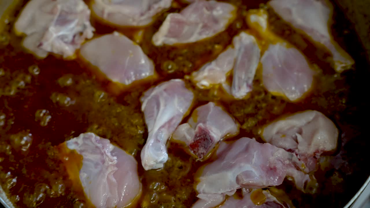 생 가금류 조각을 냄비에 끓인 카레 소스에 넣고 요리합니다.